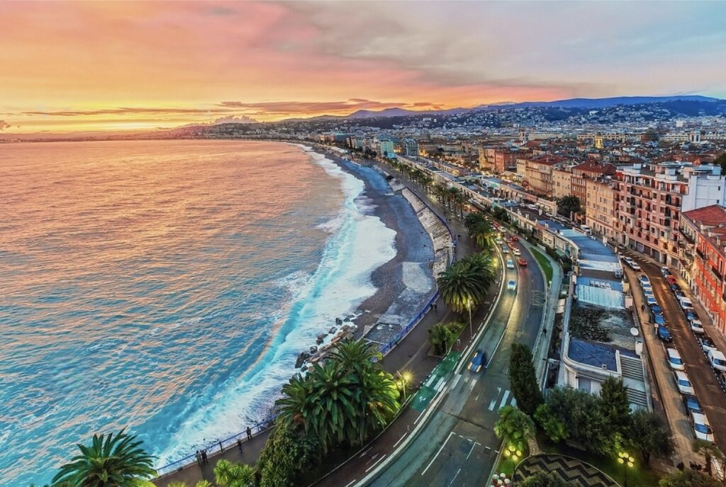 A breathtaking sunset view over Nice, with the vibrant Promenade des Anglais curving along the azure coastline, perfectly encapsulating the beauty to be discovered when spending 'Nice in one day'.