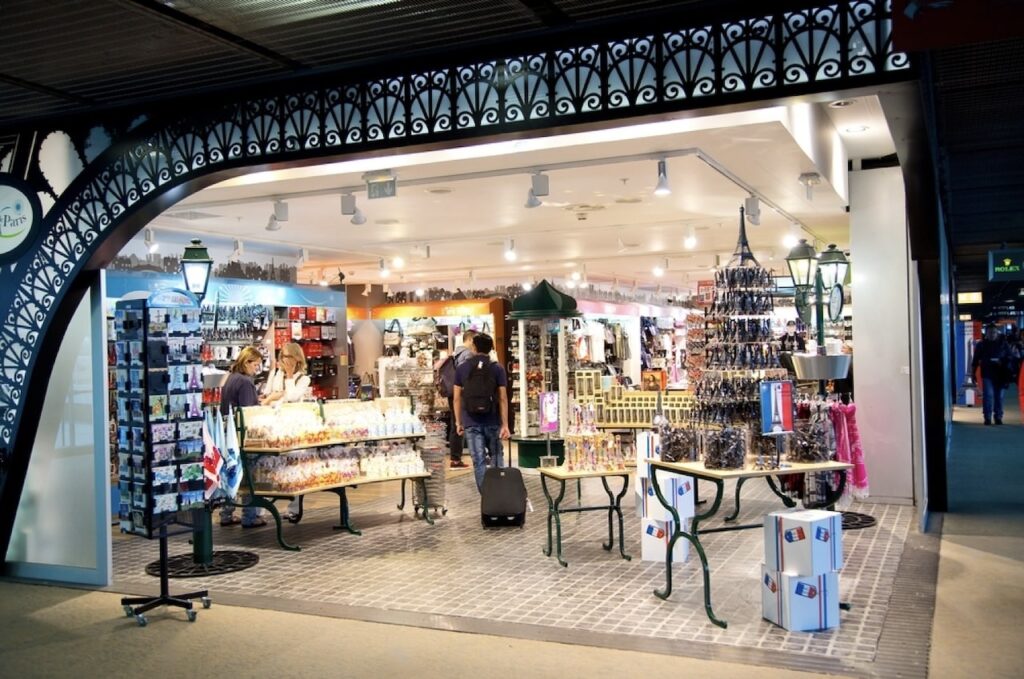 Customers browsing through souvenirs and gifts at a duty-free shop in Charles de Gaulle Airport, a location where travelers can also find SIM cards for France before their journey.