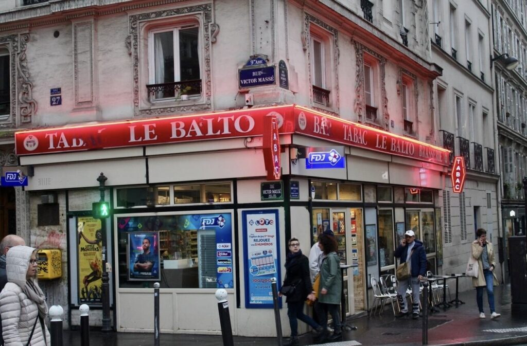 Le Balto Tabac, a quintessential Parisian corner bar and tobacco shop on a bustling street, where locals often stop by for necessities, including SIM cards for France.