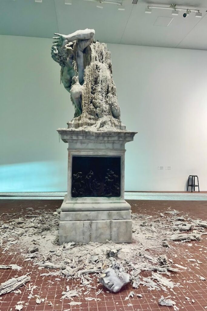 Contemporary art piece at Luma Arles depicting a classical statue in a state of dramatic decay, surrounded by debris, an intriguing exhibit for art lovers adding to the best things to do in Arles.