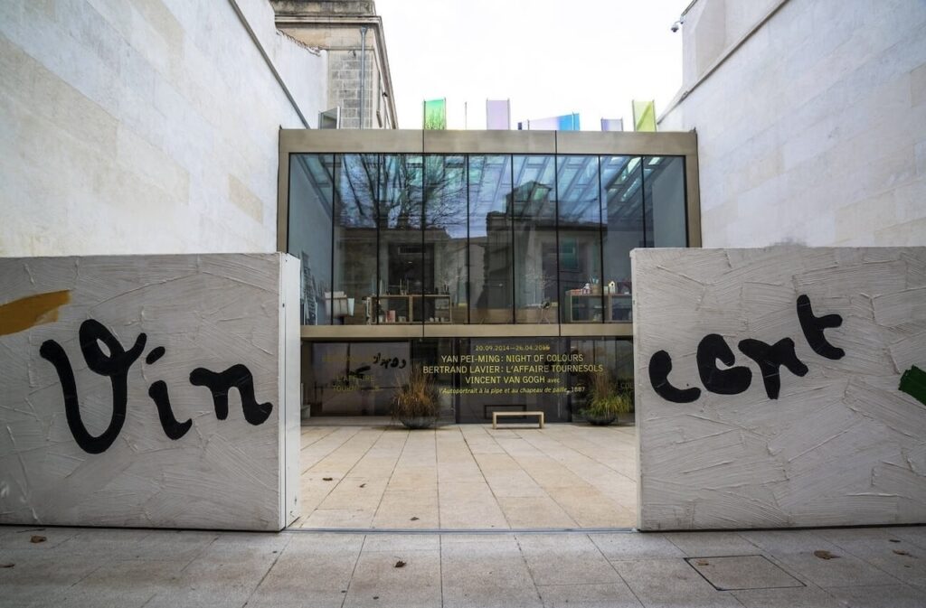 Entrance to the Fondation Vincent van Gogh in Arles, France, with 'Vincent' playfully graffiti-sprayed across concrete blocks, an inviting modern structure promising art enthusiasts one of the best things to do in Arles.