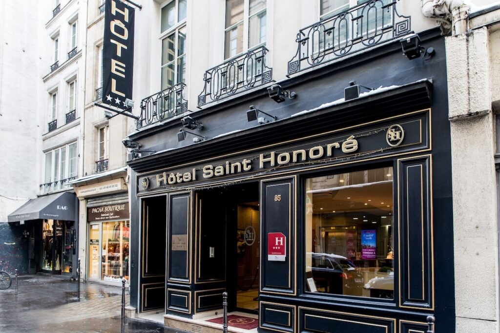 Exterior of Hôtel Saint Honoré, a top choice among the best 1st Arrondissement Paris hotels, showcasing its elegant black and gold facade on a charming Parisian street.