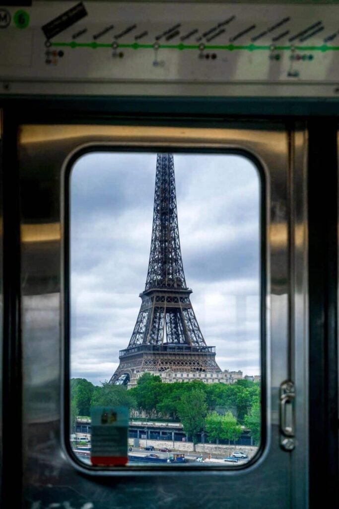 View of the Eiffel Tower from inside Metro Line 6 train window, showing how to use the Metro in Paris for scenic rides.